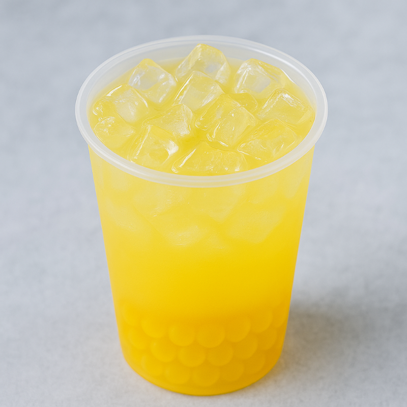 Clear plastic cup filled with yellow liquid and ice cubes on a light gray background
