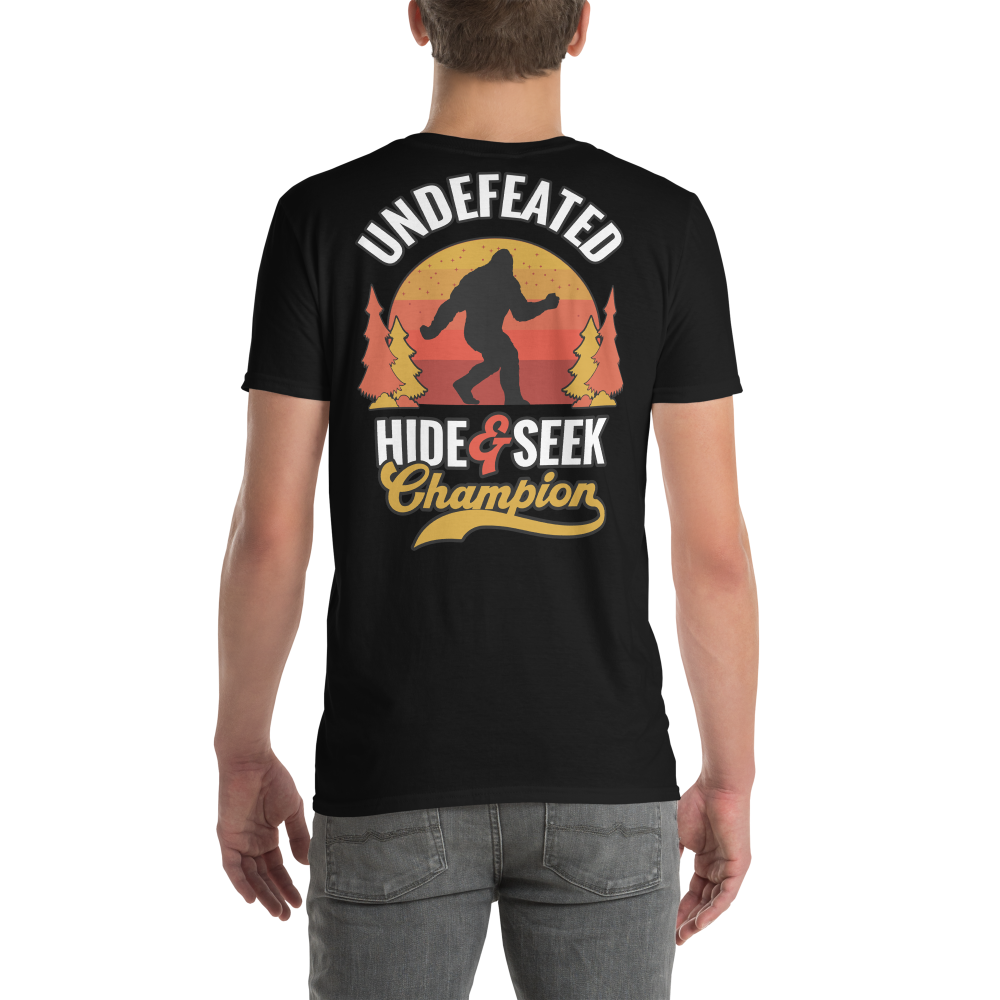 Black t-shirt with 'Undefeated Hide & Seek Champion' design featuring a silhouette of a person and trees on a white background.