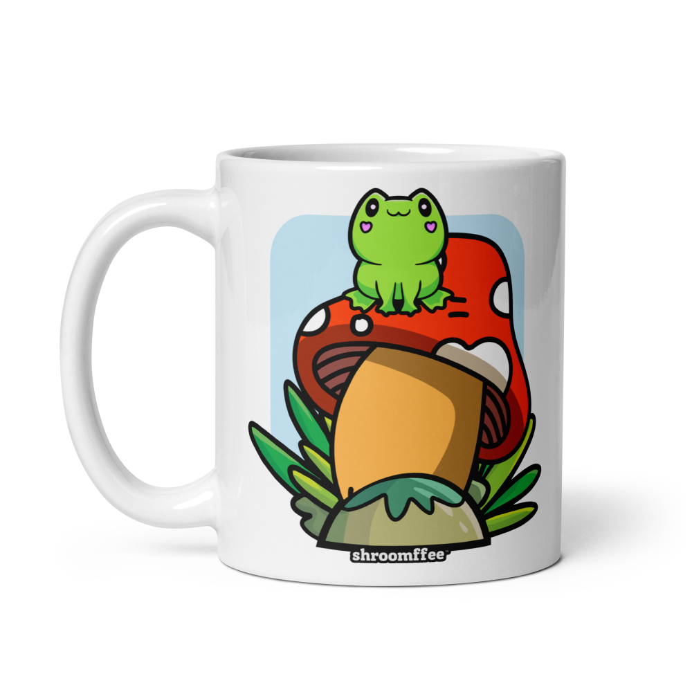 White mug with a cartoon frog on a mushroom design, brand 'shroomffee visible
