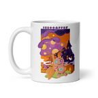 White mug with a colorful design featuring mushrooms and a house on a white background