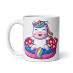 A white ceramic mug with a colorful illustration of a unicorn sitting in a pool filled with mushrooms.