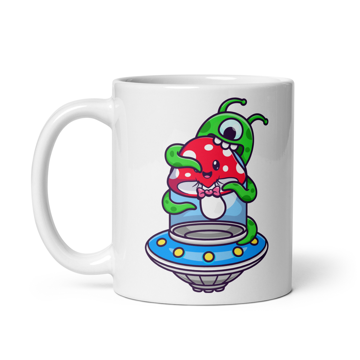 A white ceramic mug with a colorful illustration of an alien inside a flying saucer about to eat a red and green mushroom.